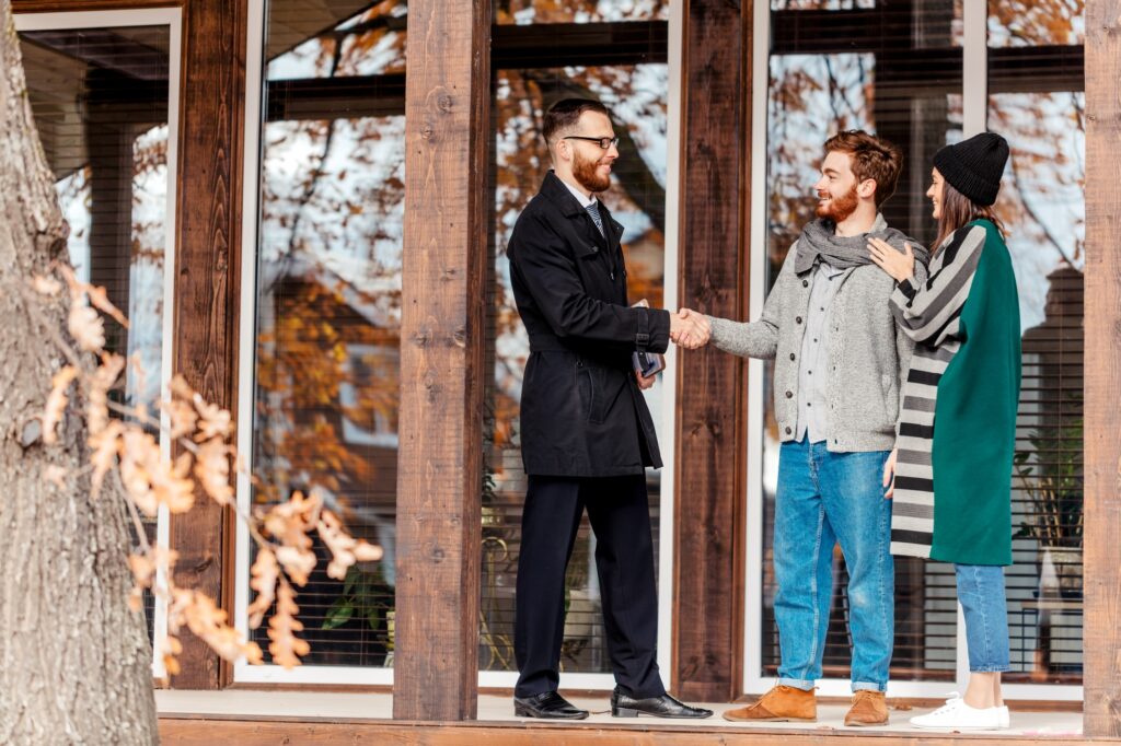 Young couple with real estate agent near house, real estate purchase